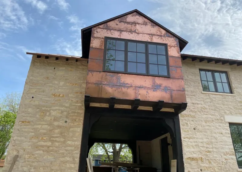 Copper metal panel facade on a stone building for Roof Repair in Crossville